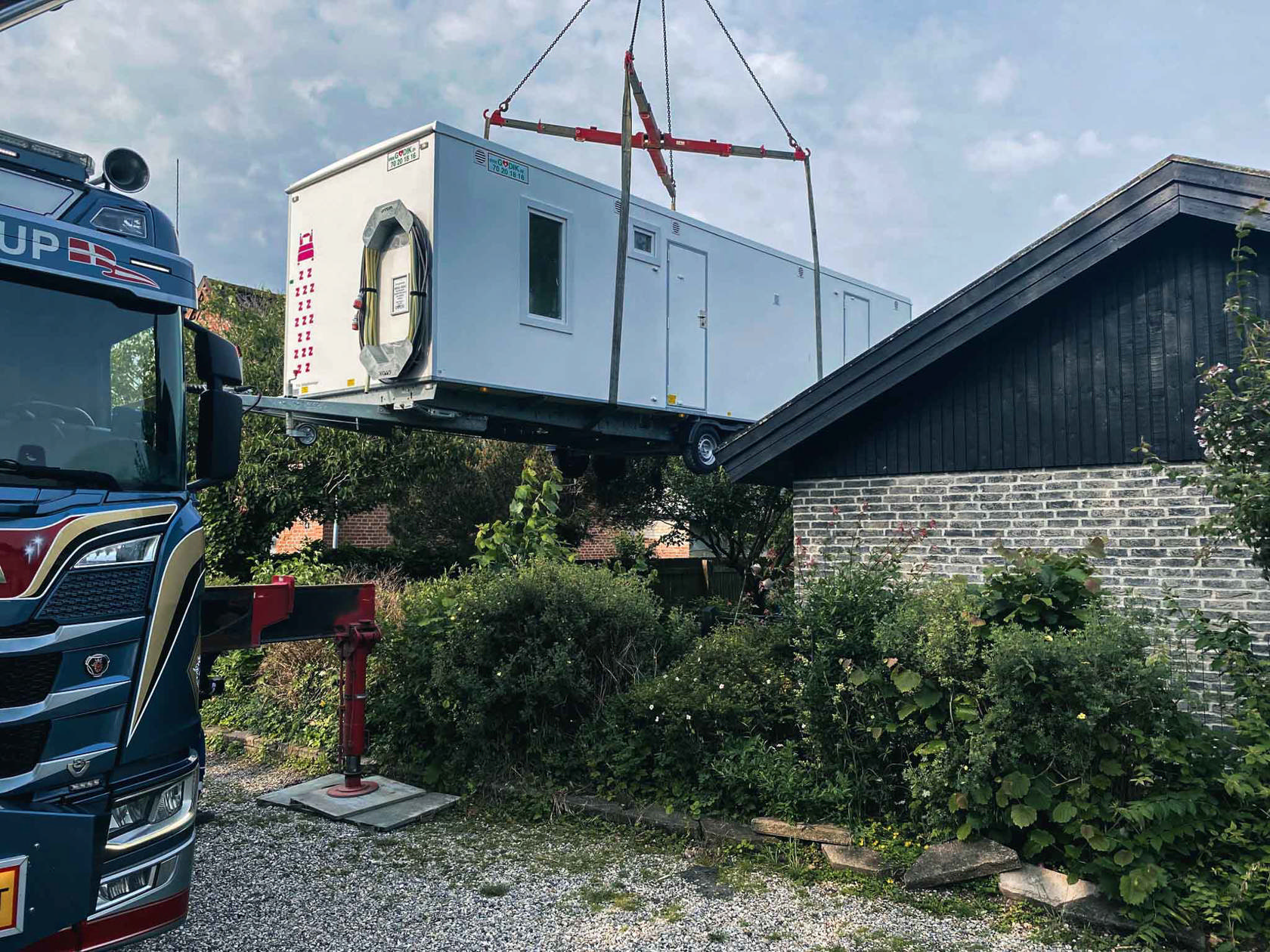 Godik beboelsesvogn løftes over hækken i forbindelse med renovering